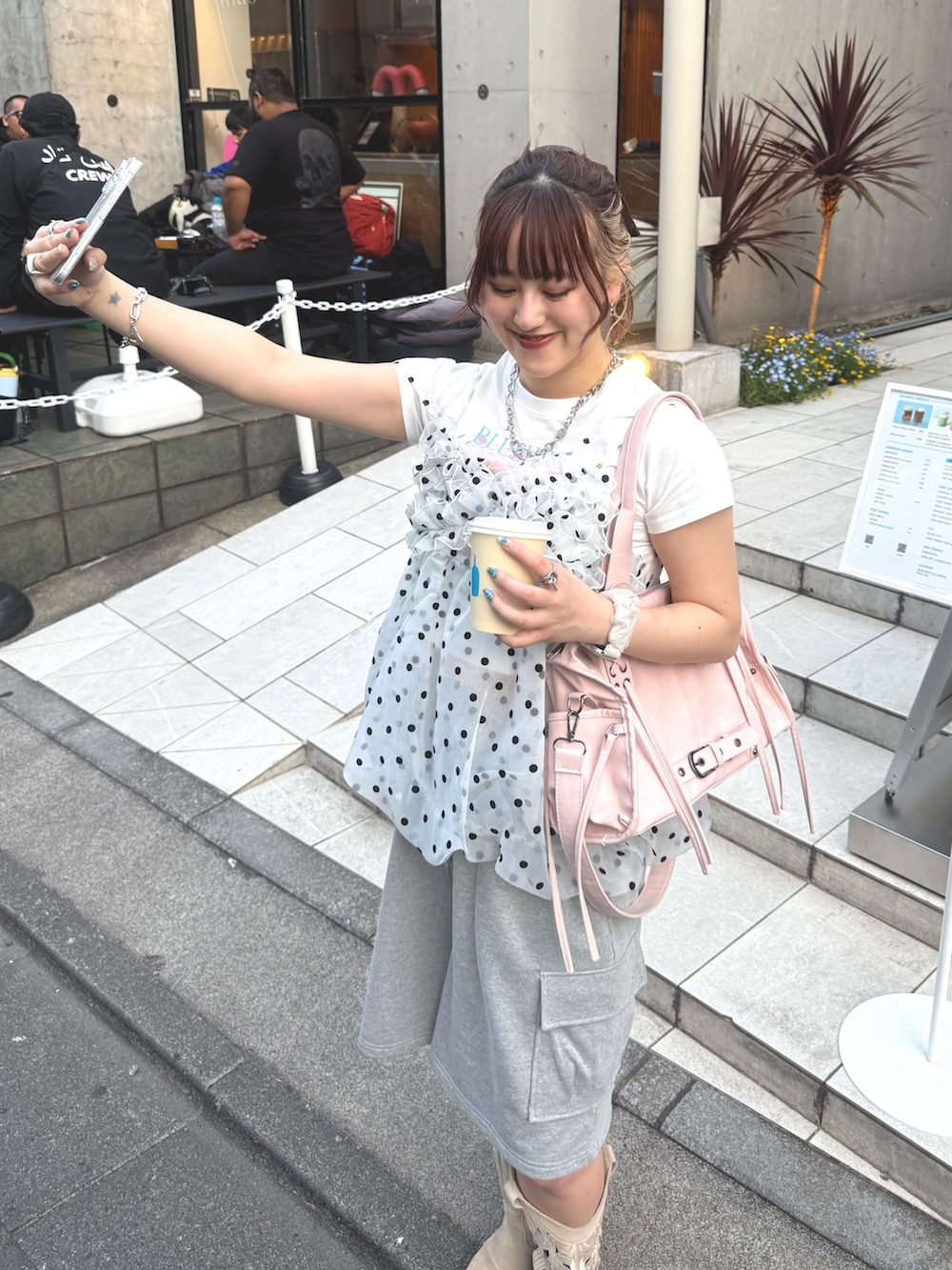 グレー系のその他パンツ、ピンク系のボストンバッグ、ホワイト系のキャミソールを着用したレディースの春コーディネートの4枚目の写真