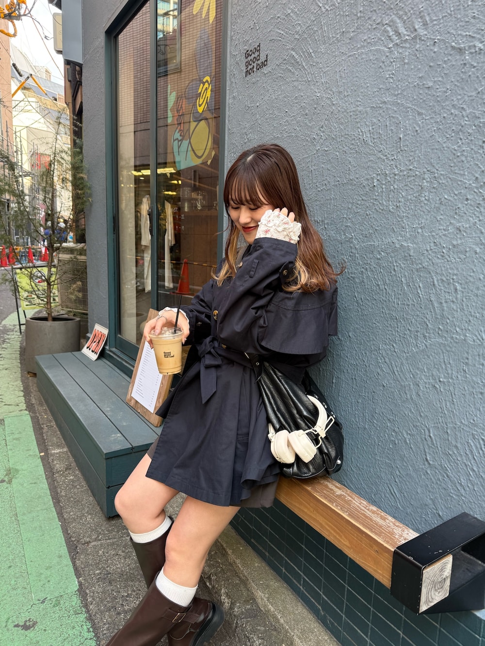 ブルー系のトレンチコート、ホワイト系のTシャツ/カットソー、ブラウン系のブーツを着用したレディースの春コーディネートの2枚目の写真