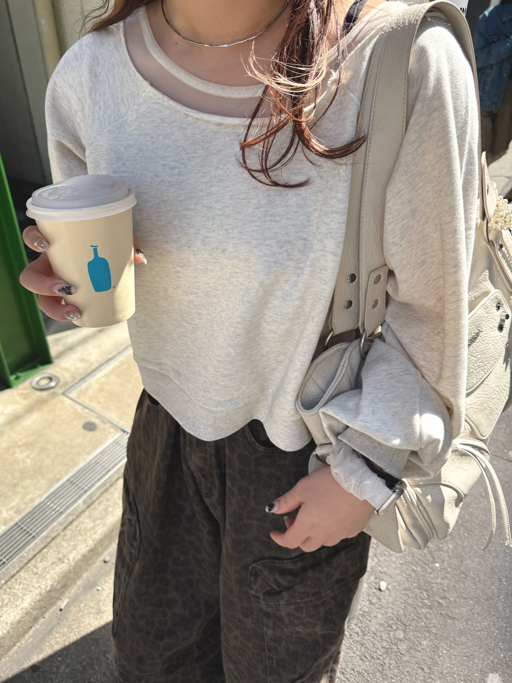 ホワイト系のTシャツ/カットソー、ブラウン系のその他パンツ、ベージュ系のショルダーバッグを着用したレディースの春コーディネートの5枚目の写真