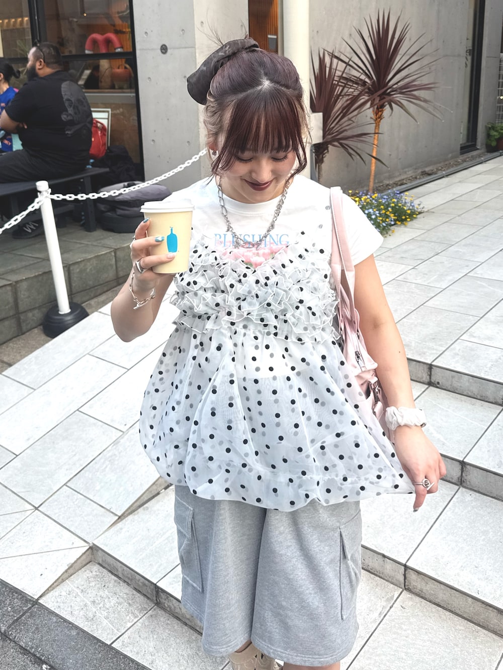 グレー系のその他パンツ、ピンク系のボストンバッグ、ホワイト系のキャミソールを着用したレディースの春コーディネートの3枚目の写真