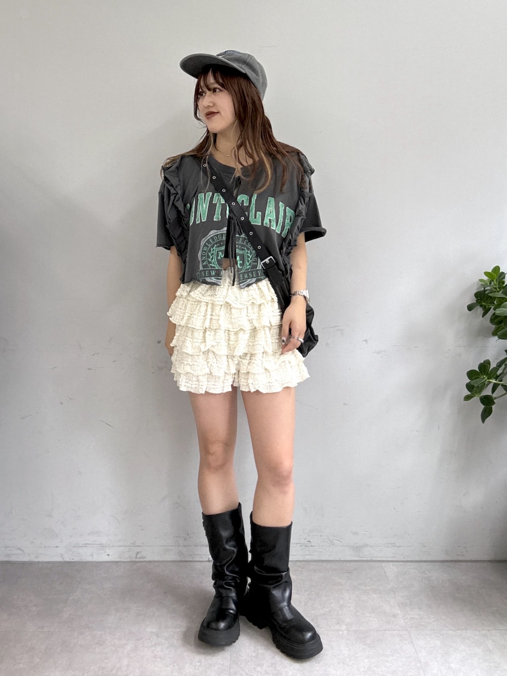 ブラック系のTシャツ/カットソー、ホワイト系のスカート、ブラック系のブーツを着用したレディースの夏コーディネートの3枚目の写真
