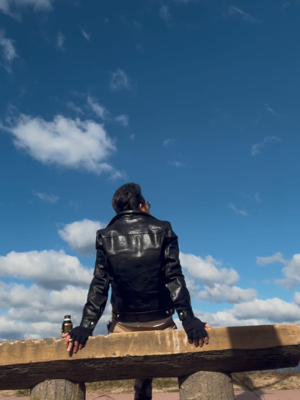 ブラック系のライダースジャケット、ベージュ系のカーゴパンツ、ブラック系のブーツを着用したメンズの秋コーディネートの2枚目の写真