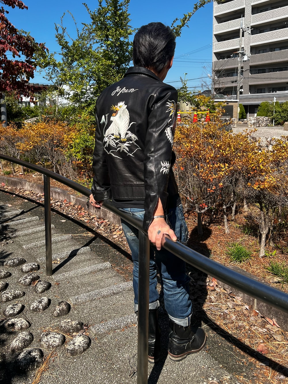 ブラック系のライダースジャケット、ブルー系のデニムパンツ、ブラック系のTシャツ/カットソーを着用したメンズの秋コーディネートの2枚目の写真