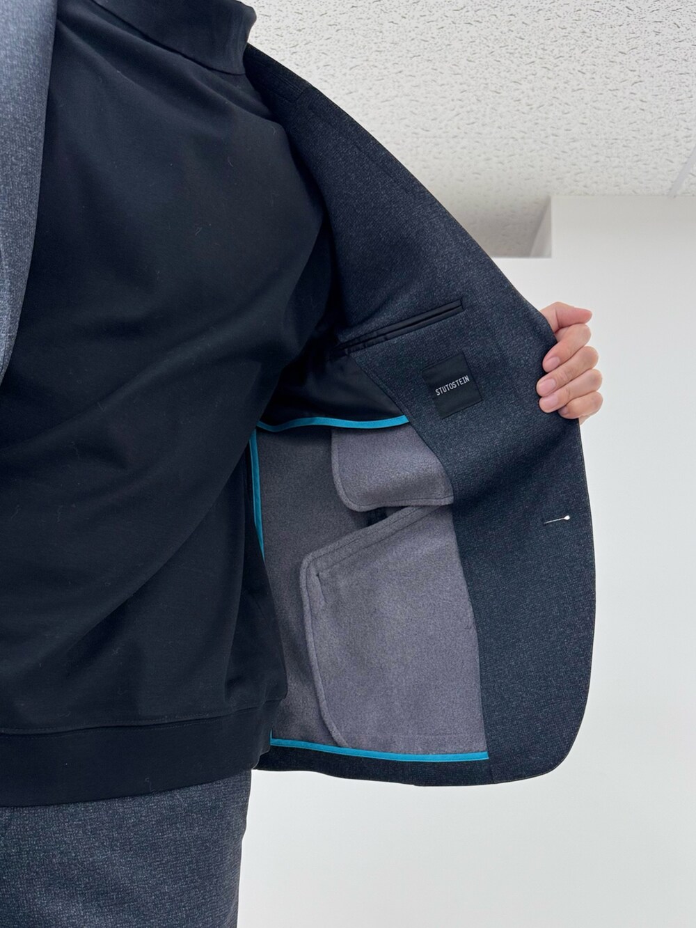 グレー系のテーラードジャケット、ブラック系のTシャツ/カットソー、グレー系のその他パンツを着用したメンズの冬コーディネートの7枚目の写真