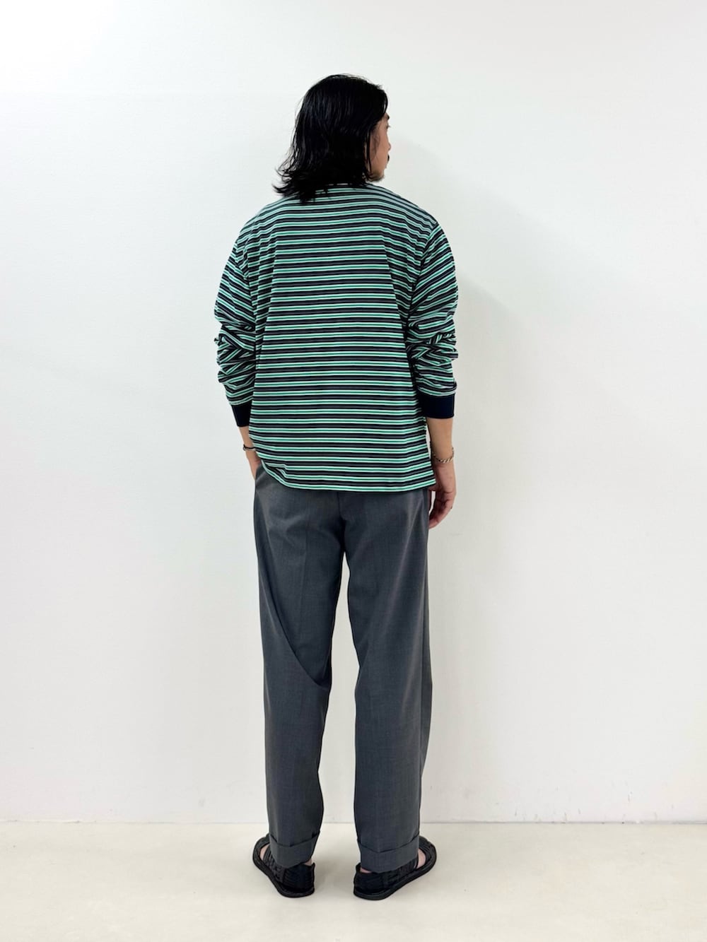 ブルー系のTシャツ/カットソー、グレー系のスラックスを着用したメンズの秋コーディネートの3枚目の写真