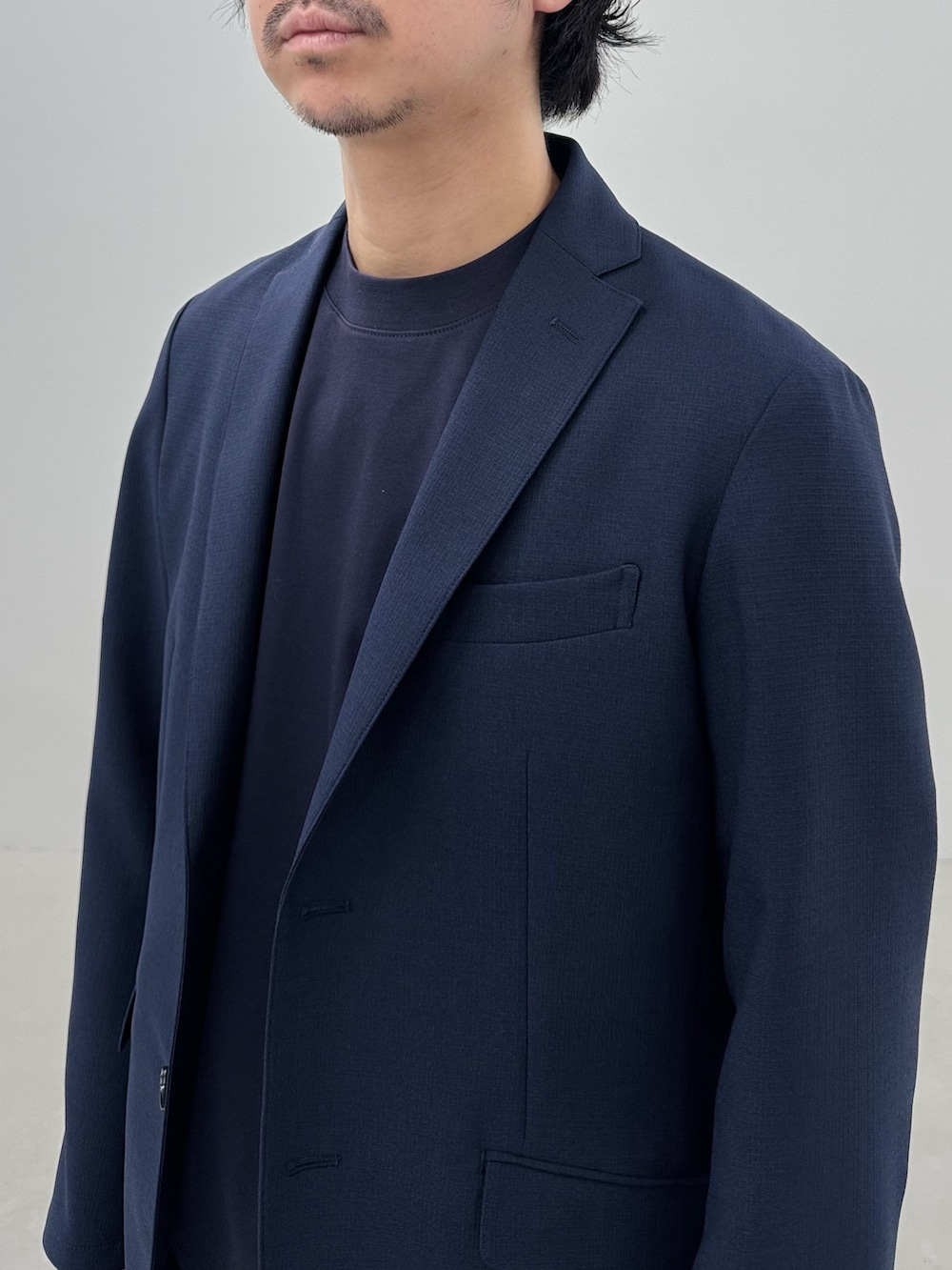 ブルー系のテーラードジャケット、ホワイト系のチノパンツ、ブラック系のローファーを着用したメンズの冬コーディネートの4枚目の写真