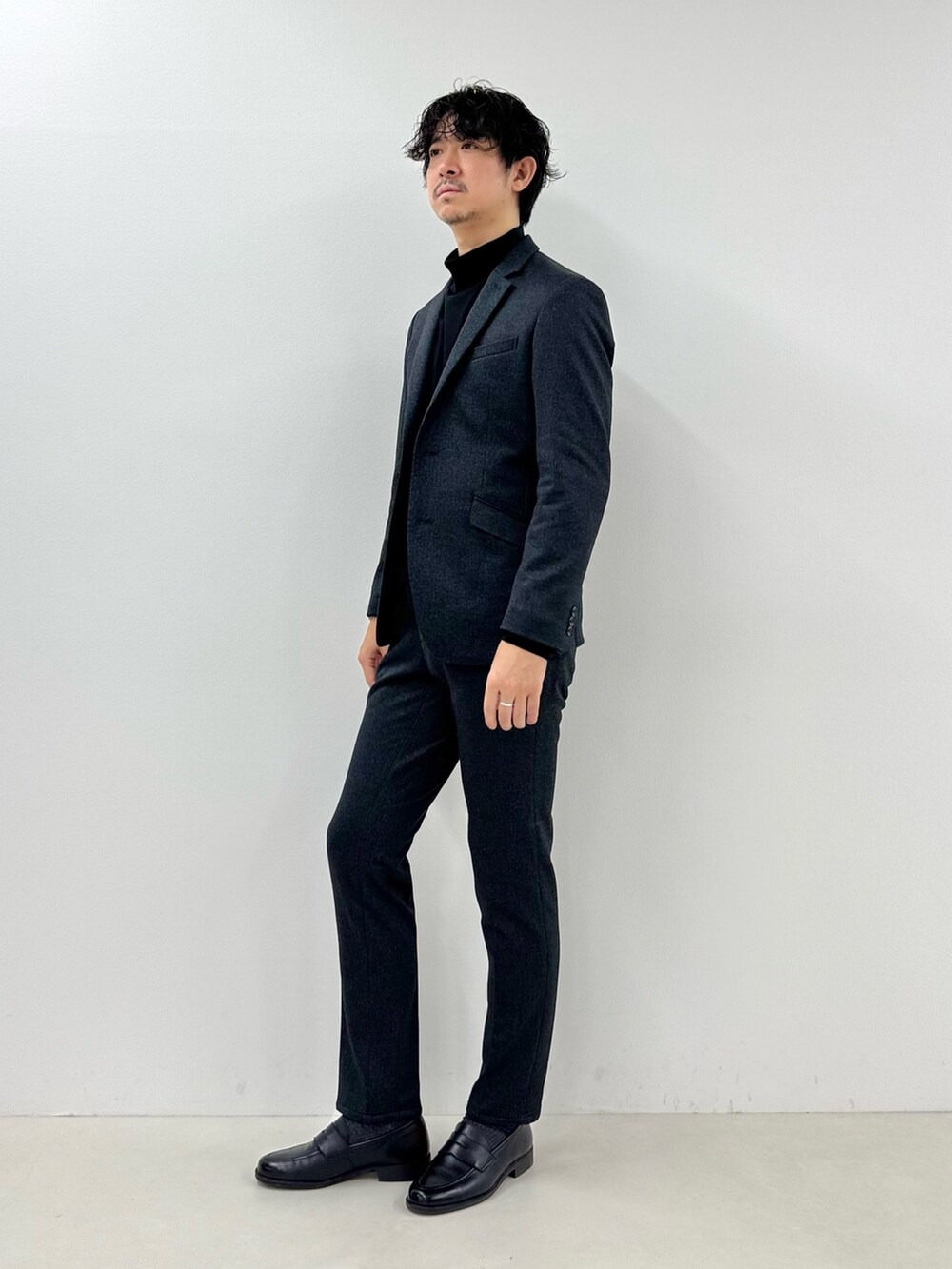 グレー系のテーラードジャケット、ブラック系のTシャツ/カットソー、グレー系のその他パンツを着用したメンズの冬コーディネートの3枚目の写真