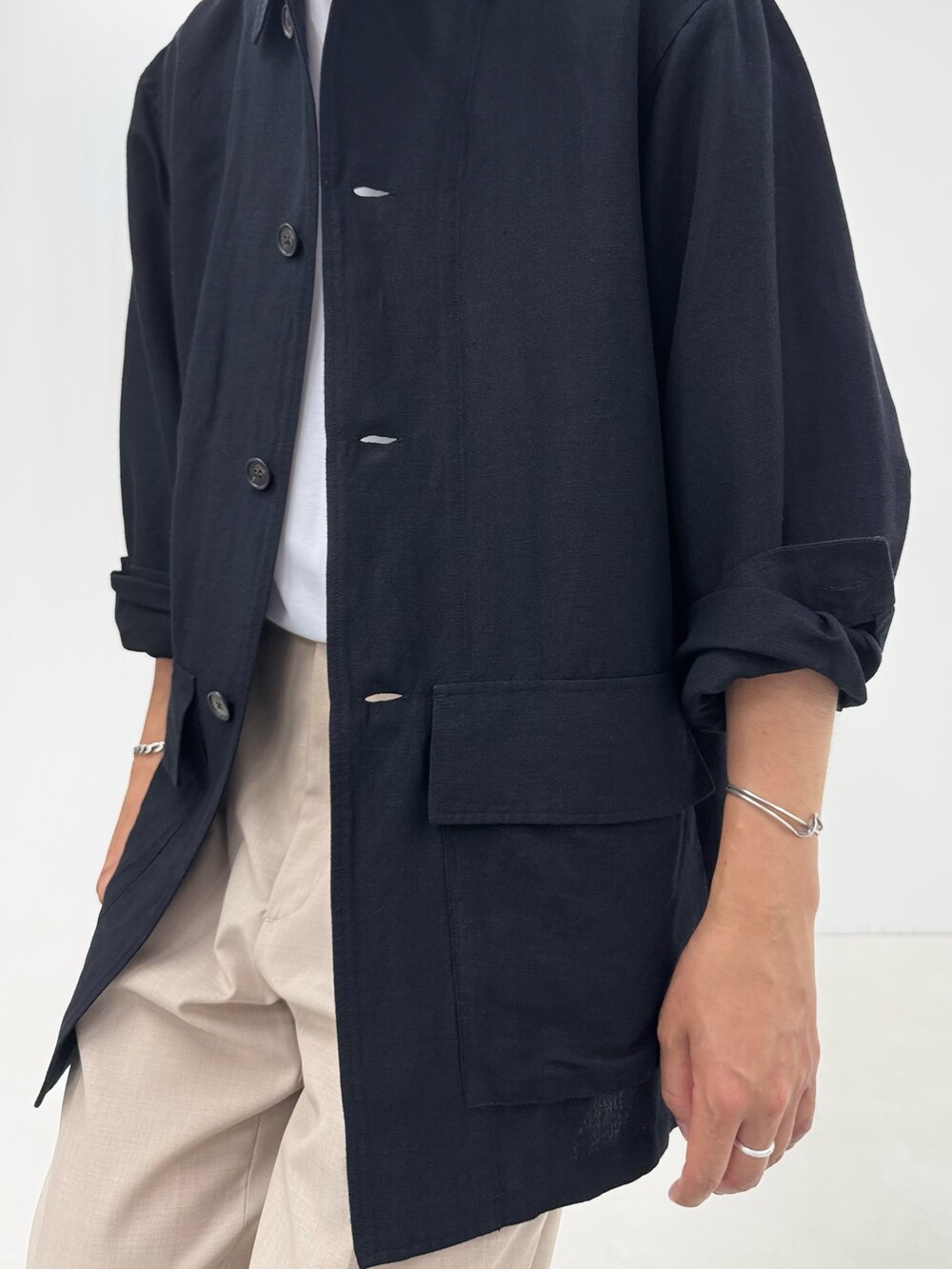 ブラック系のシャツ/ブラウス、ホワイト系のTシャツ/カットソー、ベージュ系のスラックスを着用したメンズの夏コーディネートの6枚目の写真