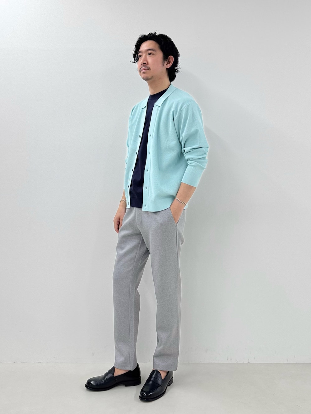 ブルー系のカーディガン/ボレロ、グレー系のその他パンツ、ブラック系のローファーを着用したメンズの冬コーディネートの2枚目の写真