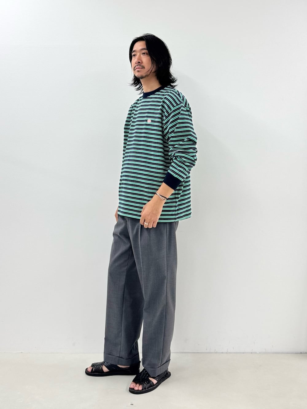 ブルー系のTシャツ/カットソー、グレー系のスラックスを着用したメンズの秋コーディネートの2枚目の写真