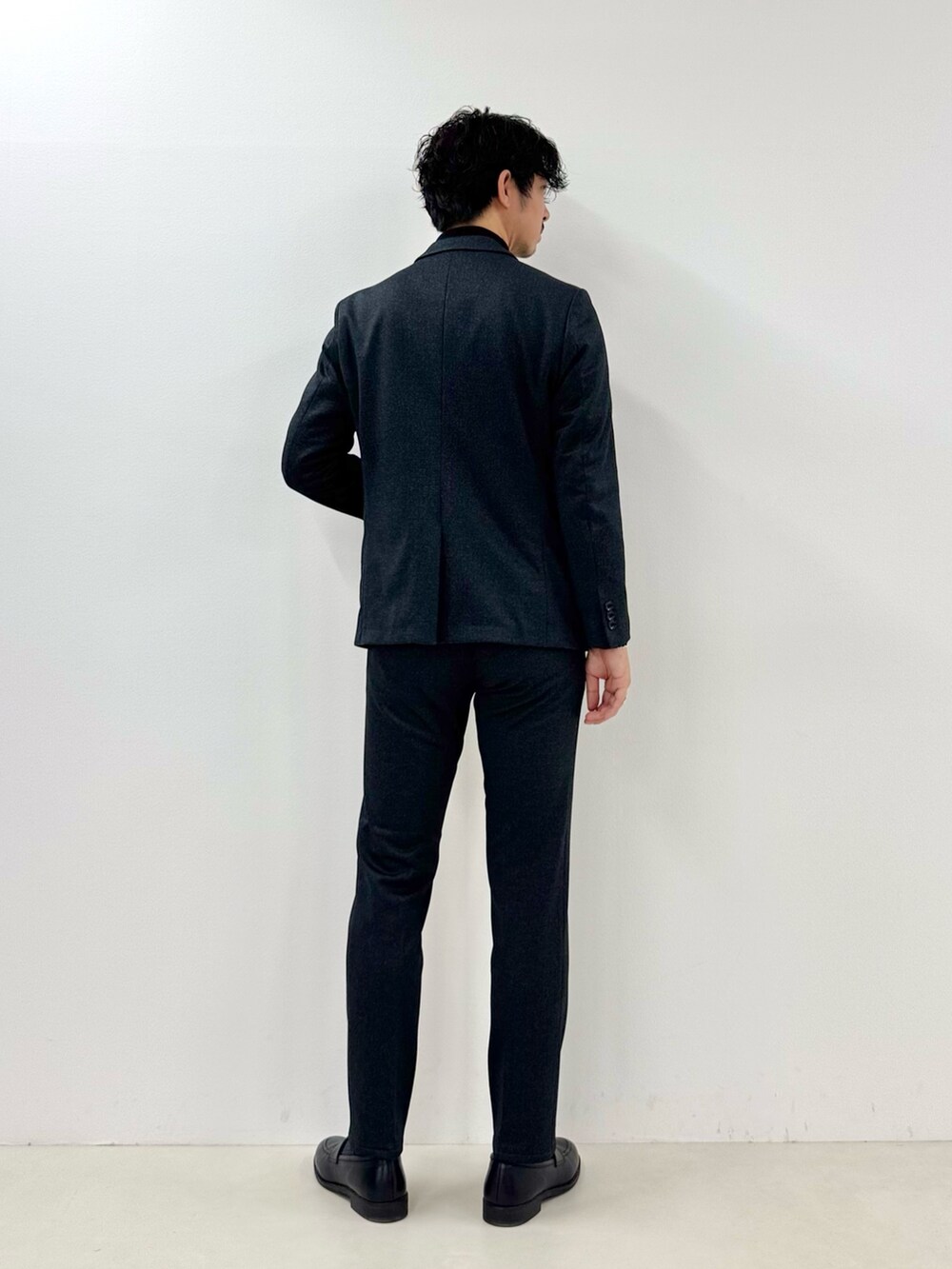 グレー系のテーラードジャケット、ブラック系のTシャツ/カットソー、グレー系のその他パンツを着用したメンズの冬コーディネートの4枚目の写真