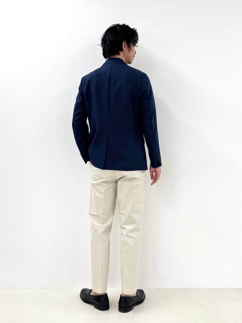 ブルー系のテーラードジャケット、ホワイト系のチノパンツ、ブラック系のローファーを着用したメンズの冬コーディネートの3枚目の写真