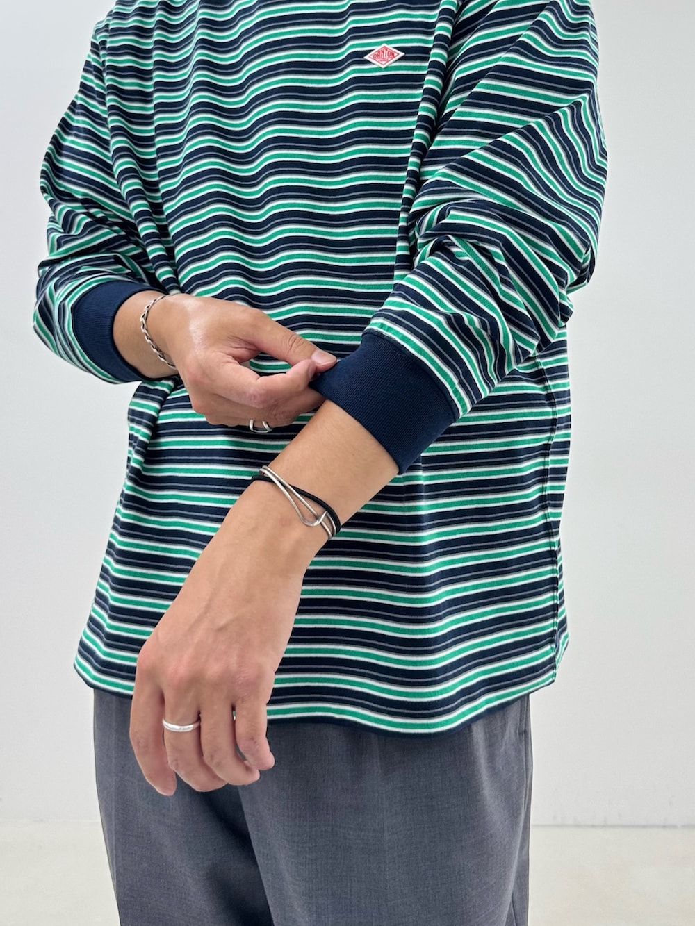 ブルー系のTシャツ/カットソー、グレー系のスラックスを着用したメンズの秋コーディネートの5枚目の写真