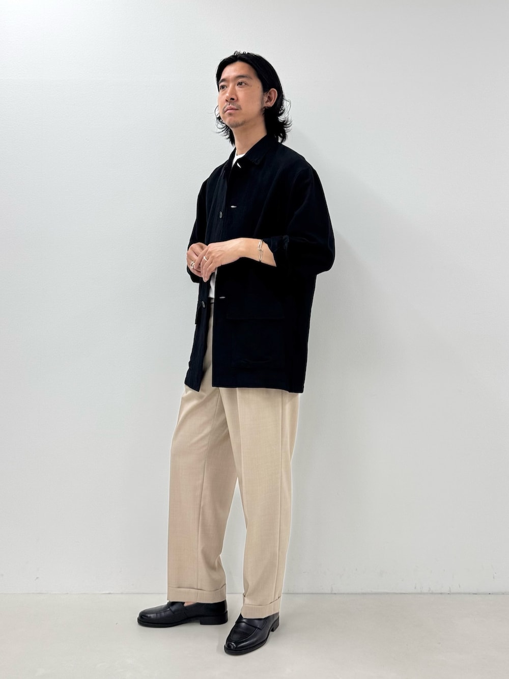 ブラック系のシャツ/ブラウス、ホワイト系のTシャツ/カットソー、ベージュ系のスラックスを着用したメンズの夏コーディネートの2枚目の写真