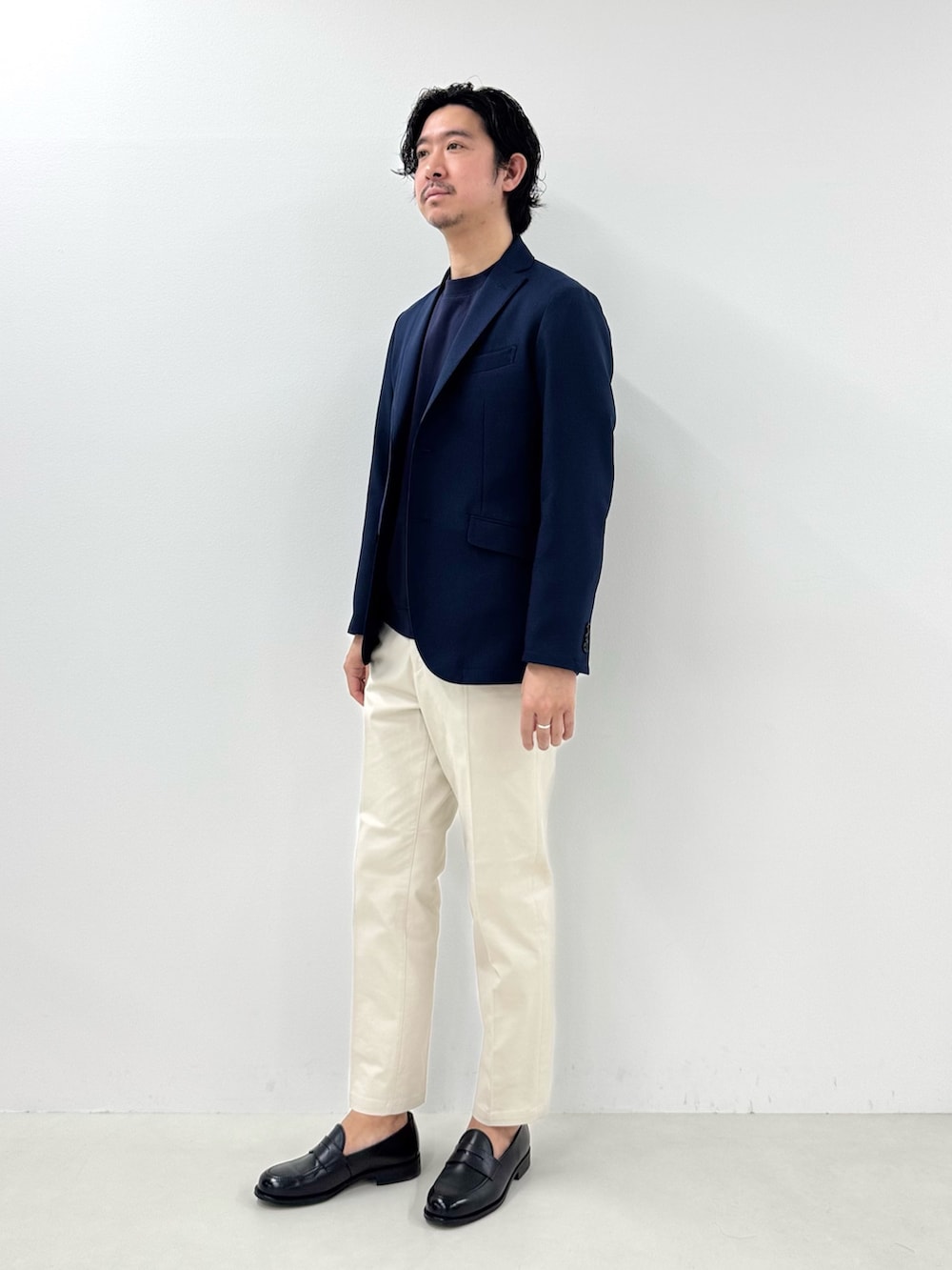 ブルー系のテーラードジャケット、ホワイト系のチノパンツ、ブラック系のローファーを着用したメンズの冬コーディネートの2枚目の写真