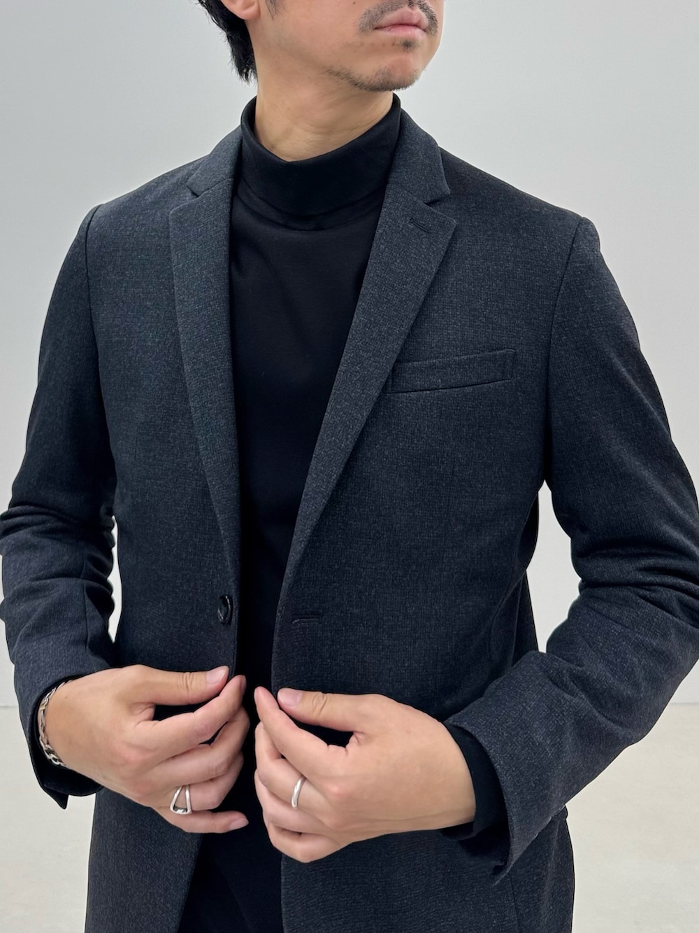 グレー系のテーラードジャケット、ブラック系のTシャツ/カットソー、グレー系のその他パンツを着用したメンズの冬コーディネートの5枚目の写真