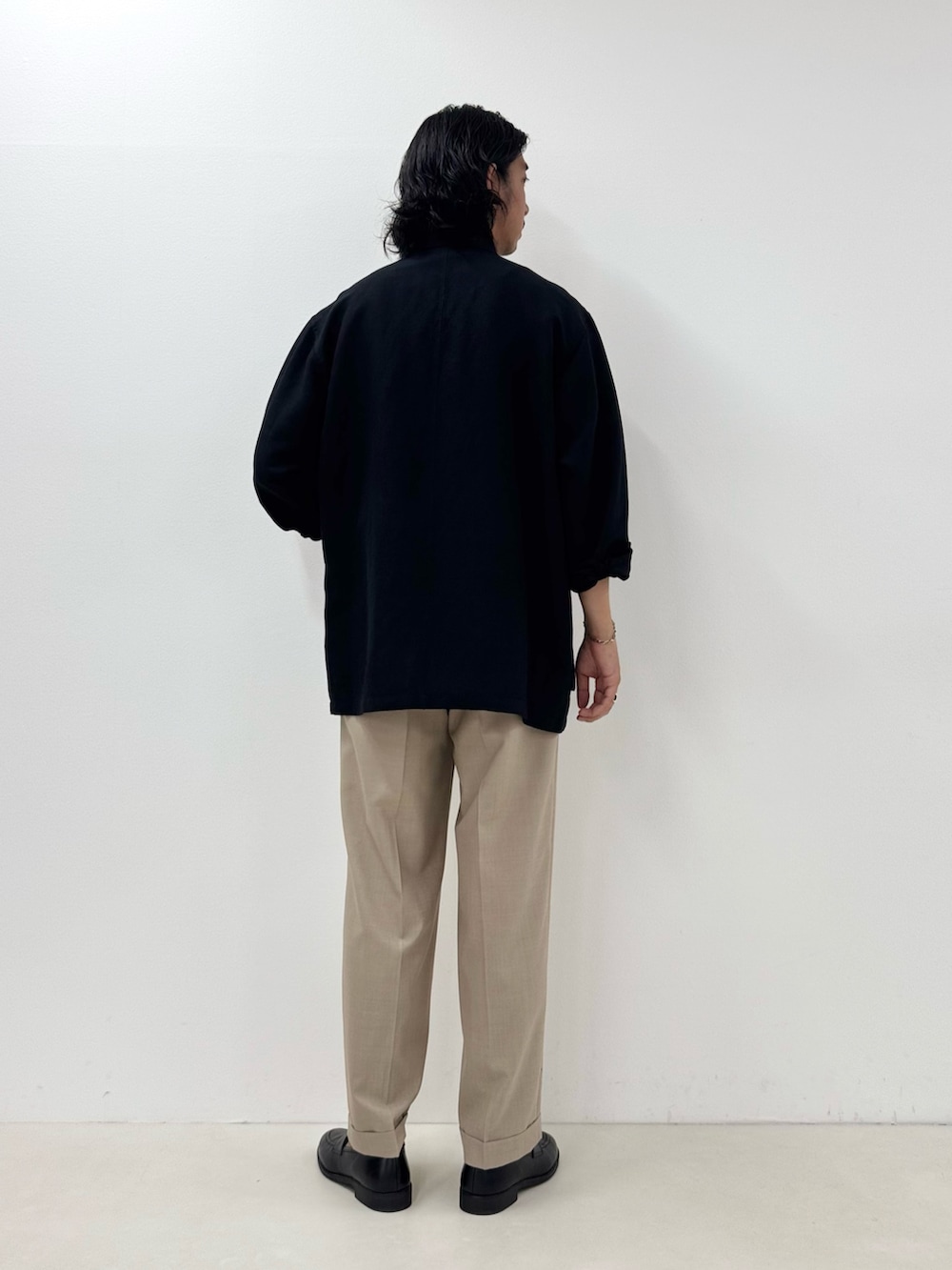 ブラック系のシャツ/ブラウス、ホワイト系のTシャツ/カットソー、ベージュ系のスラックスを着用したメンズの夏コーディネートの3枚目の写真