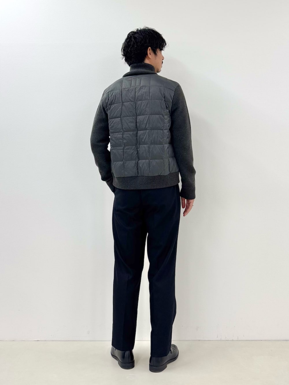 グレー系のブルゾン、イエロー系のTシャツ/カットソー、ブラック系のスラックスを着用したメンズの秋コーディネートの3枚目の写真