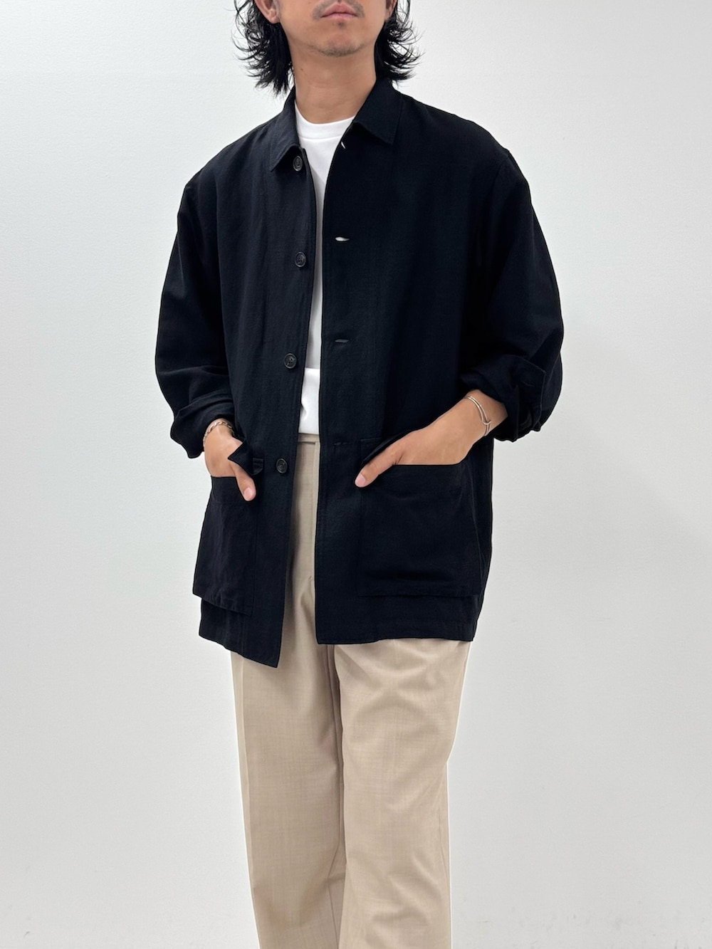 ブラック系のシャツ/ブラウス、ホワイト系のTシャツ/カットソー、ベージュ系のスラックスを着用したメンズの夏コーディネートの4枚目の写真