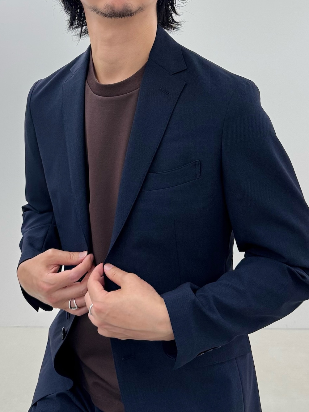 ブルー系のテーラードジャケット、ブラウン系のTシャツ/カットソー、ブルー系のスラックスを着用したメンズの春コーディネートの4枚目の写真