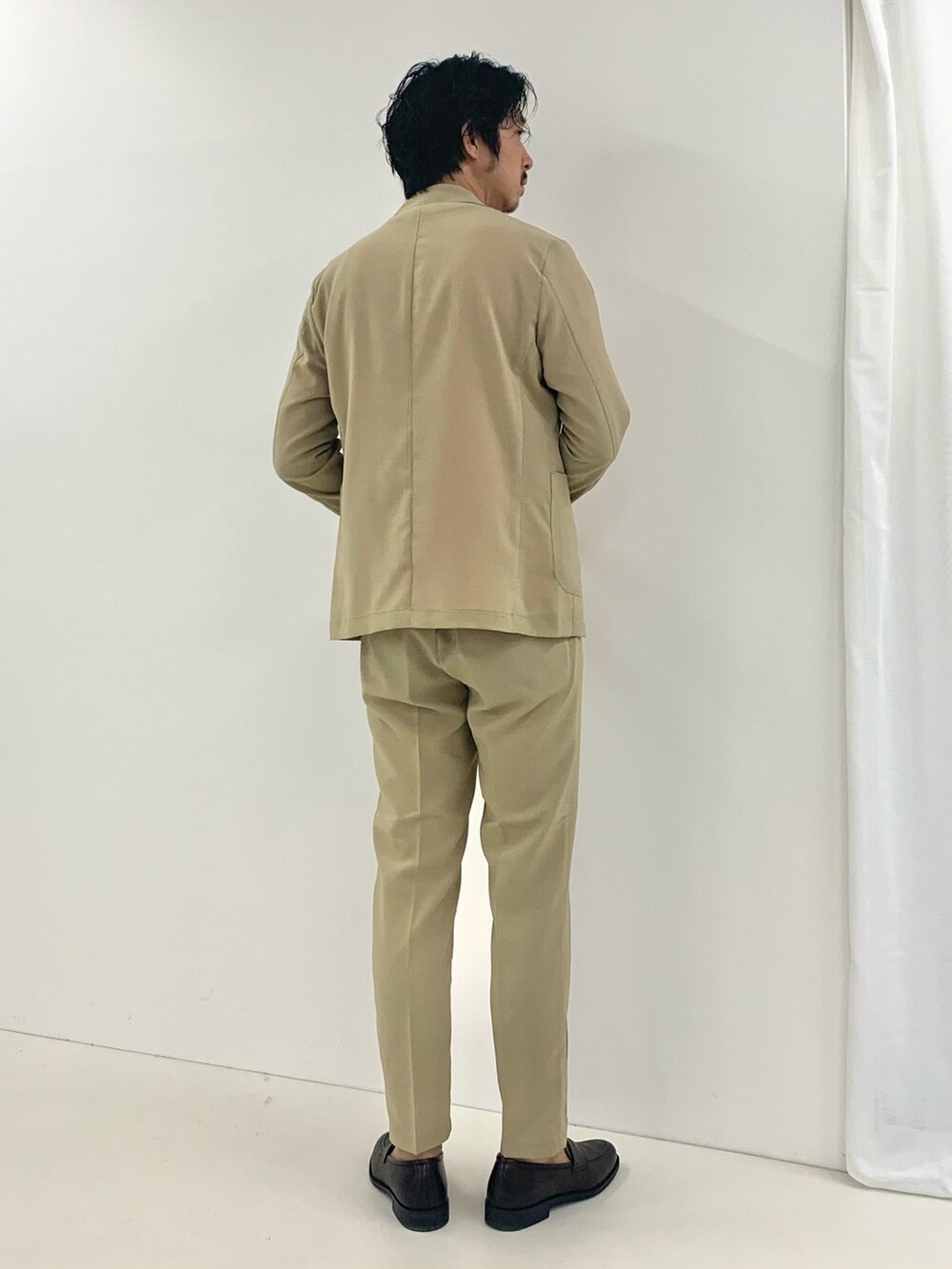 ベージュ系のテーラードジャケット、ベージュ系のその他パンツ、ブラウン系のローファーを着用したメンズの夏コーディネートの2枚目の写真