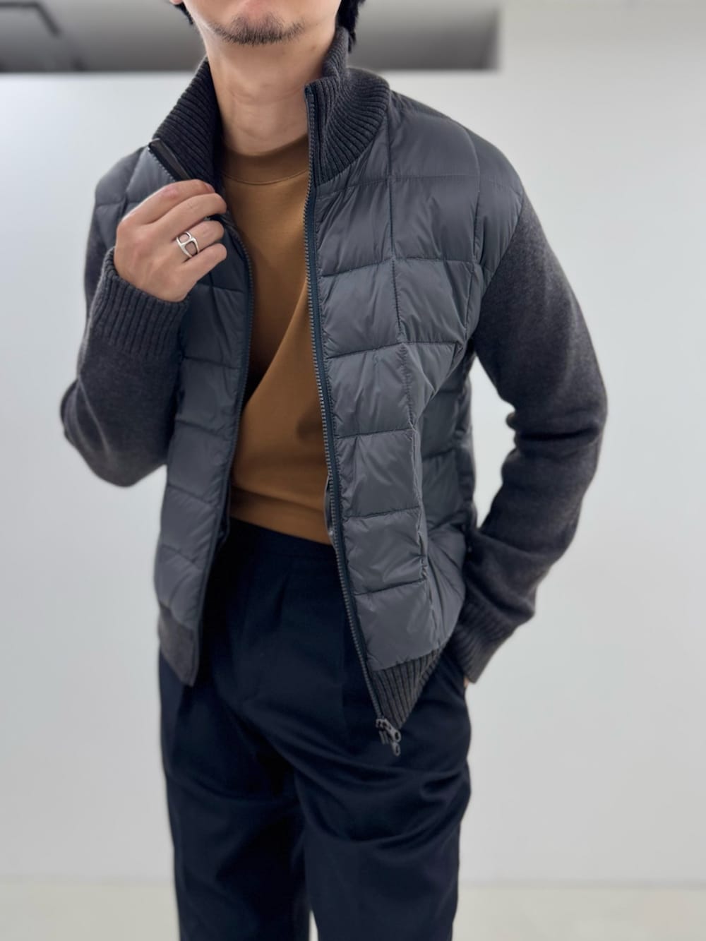 グレー系のブルゾン、イエロー系のTシャツ/カットソー、ブラック系のスラックスを着用したメンズの秋コーディネートの4枚目の写真