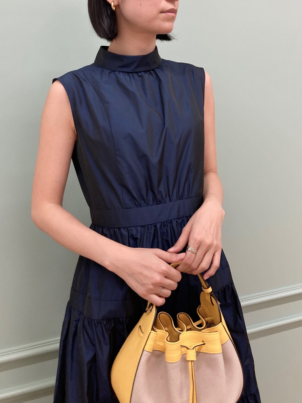 ブルー系のワンピース/ドレス、イエロー系のハンドバッグを着用したレディースの冬コーディネートの4枚目の写真