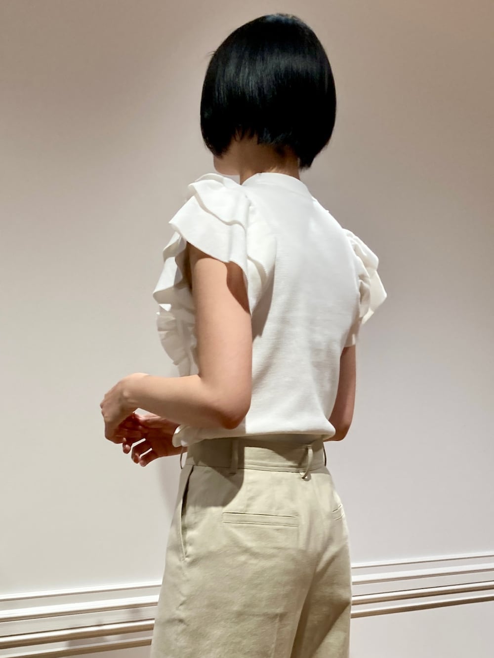 ホワイト系のニット/セーター、ベージュ系のその他パンツを着用したレディースの春コーディネートの4枚目の写真