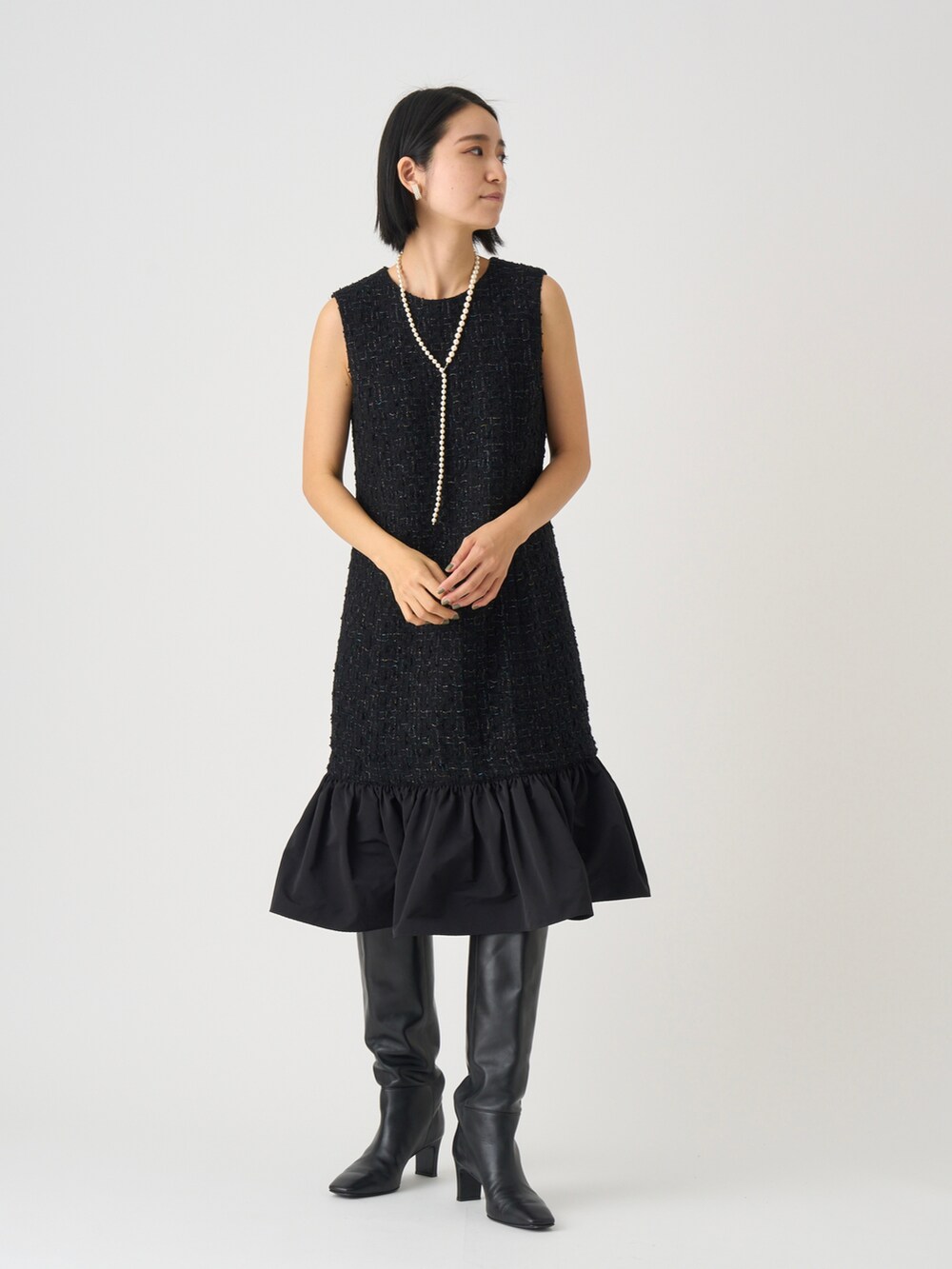 ブラック系のワンピース、ホワイト系のネックレスを着用したレディースの秋コーディネートの2枚目の写真