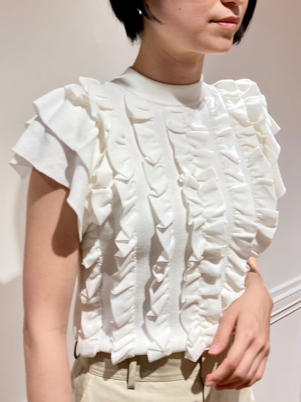 ホワイト系のニット/セーター、ベージュ系のその他パンツを着用したレディースの春コーディネートの3枚目の写真