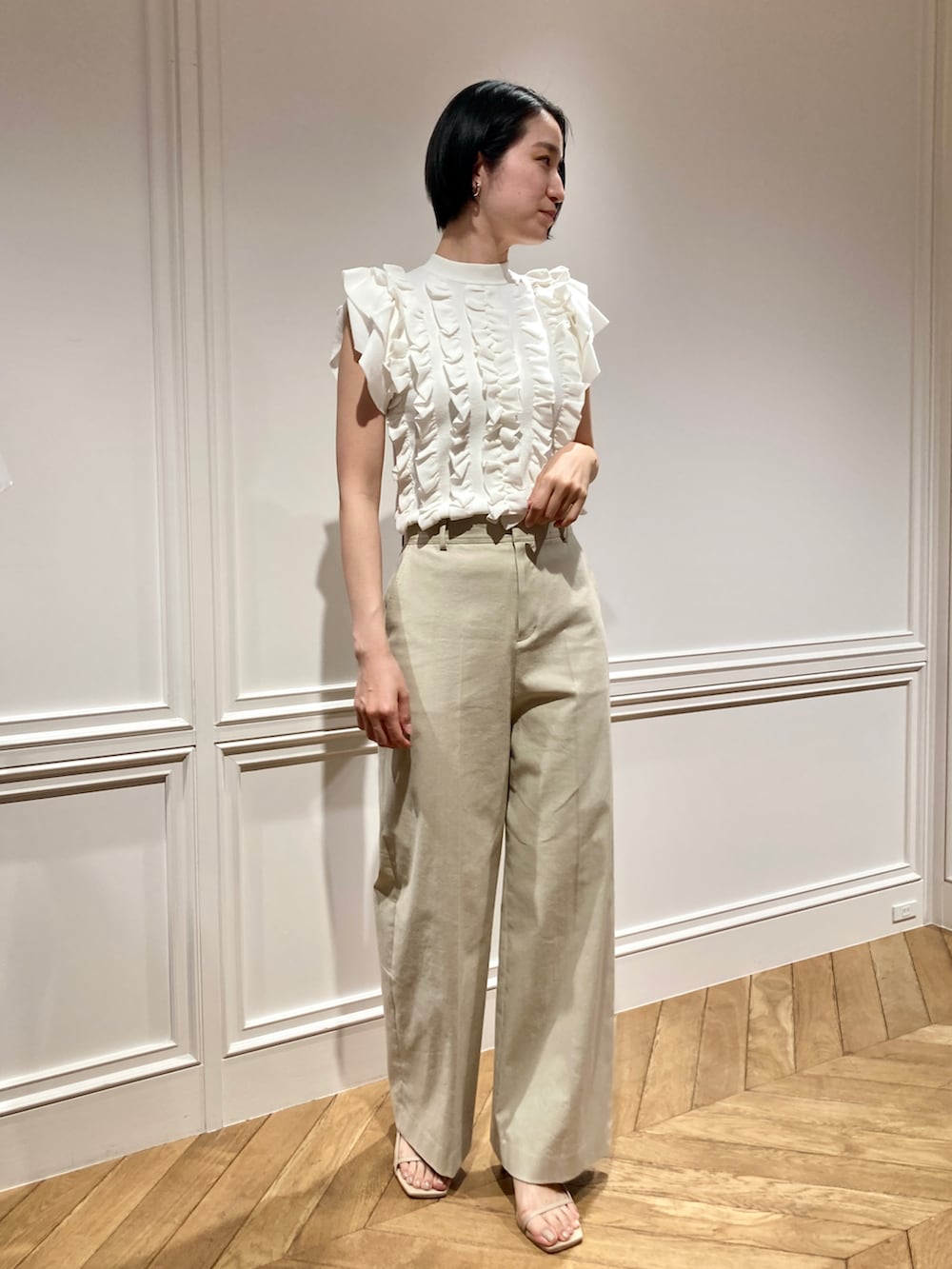 ホワイト系のニット/セーター、ベージュ系のその他パンツを着用したレディースの春コーディネートの2枚目の写真