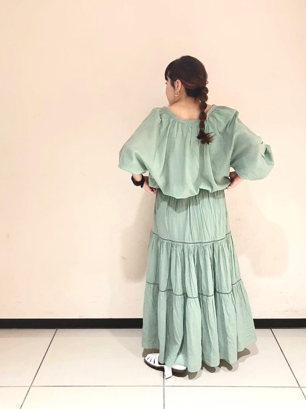 グリーン系のシャツ/ブラウス、グリーン系のスカート、ホワイト系のサンダルを着用したレディースの春コーディネートの3枚目の写真