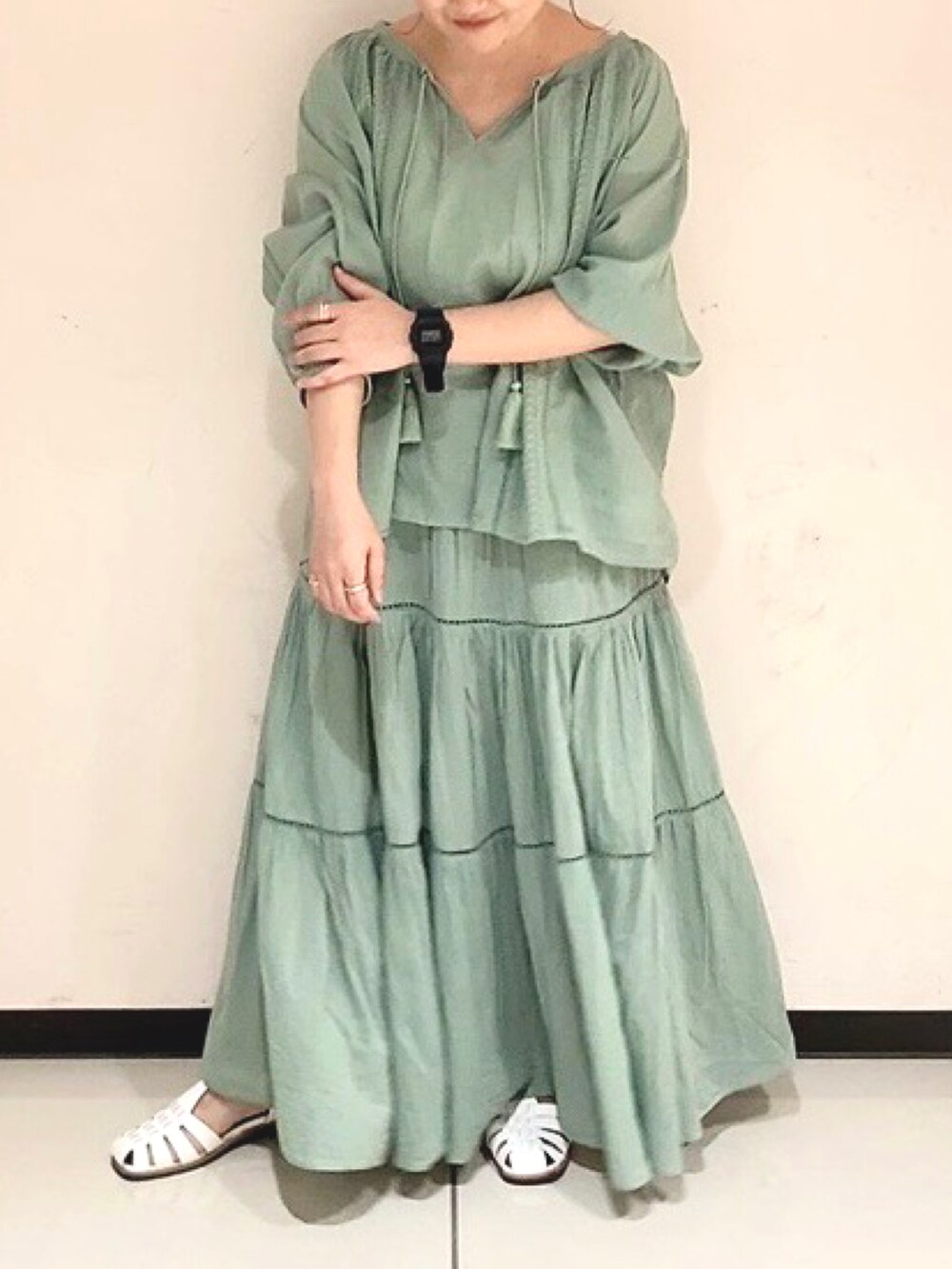 グリーン系のシャツ/ブラウス、グリーン系のスカート、ホワイト系のサンダルを着用したレディースの春コーディネートの4枚目の写真