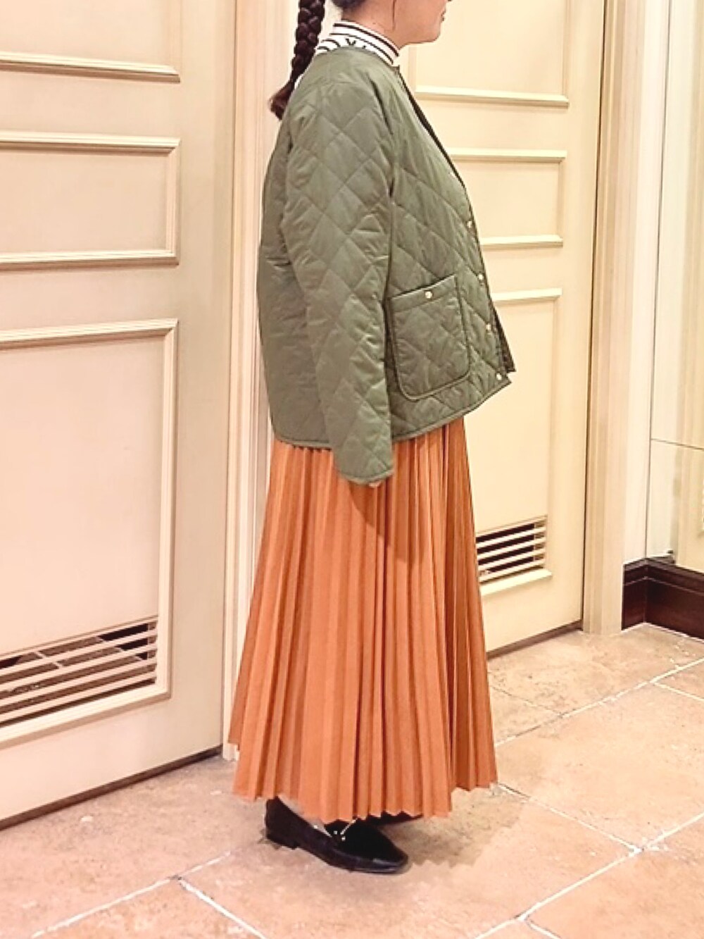 ブラウン系のスカート、ホワイト系のニット/セーター、ブラック系のドレスシューズを着用したレディースの秋コーディネートの2枚目の写真