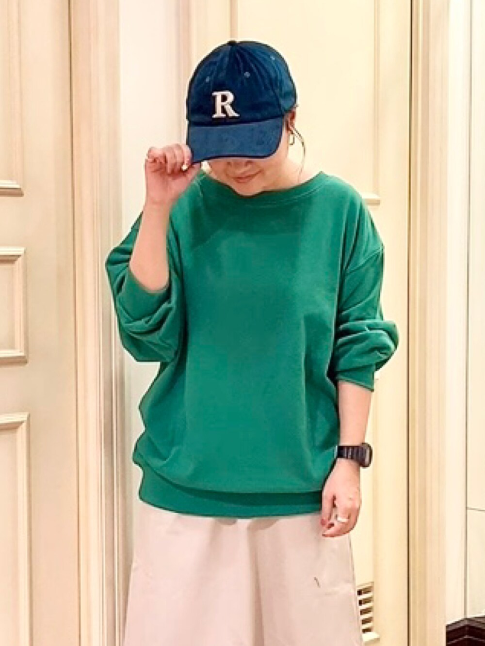 ブラック系のスニーカー、グリーン系のTシャツ/カットソー、ホワイト系のスカートを着用したレディースの秋コーディネートの4枚目の写真