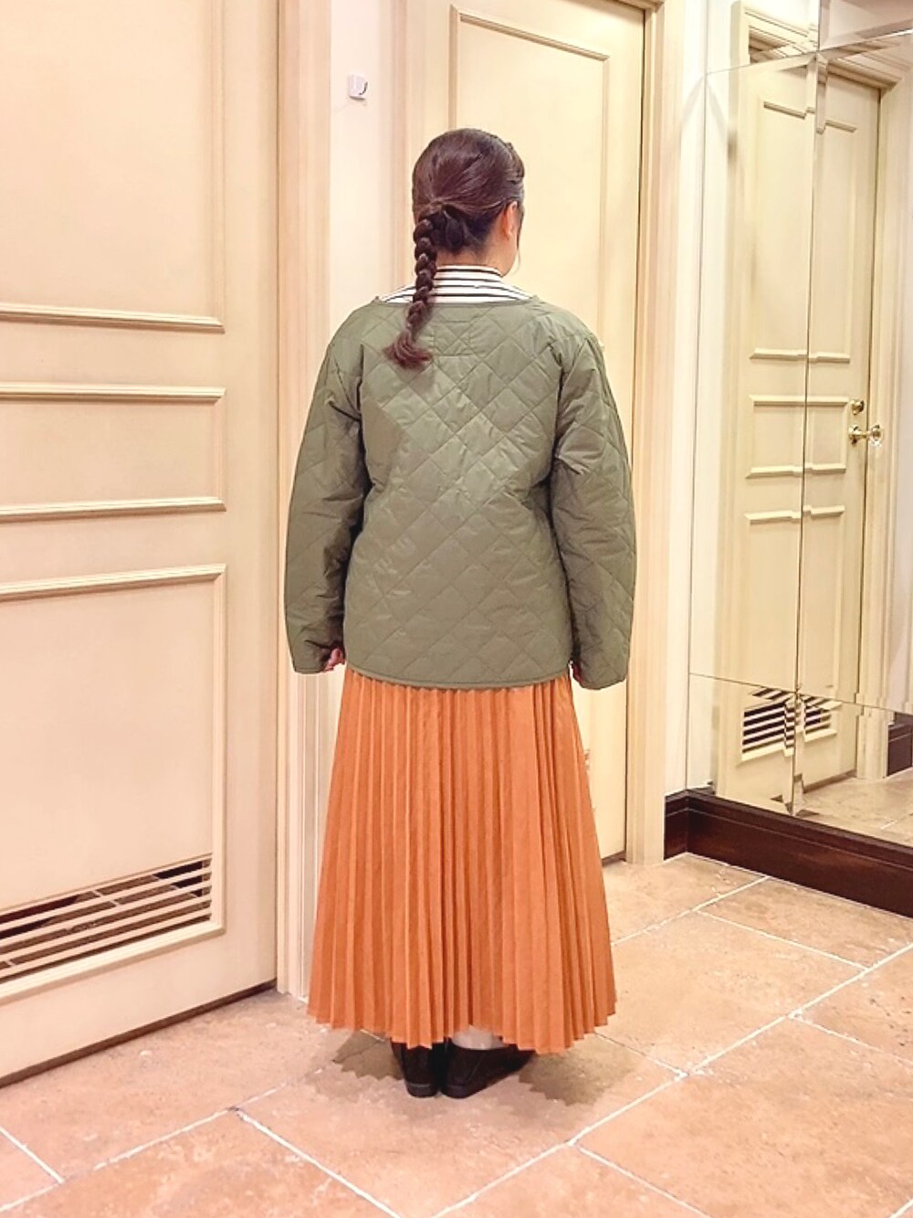 ブラウン系のスカート、ホワイト系のニット/セーター、ブラック系のドレスシューズを着用したレディースの秋コーディネートの3枚目の写真