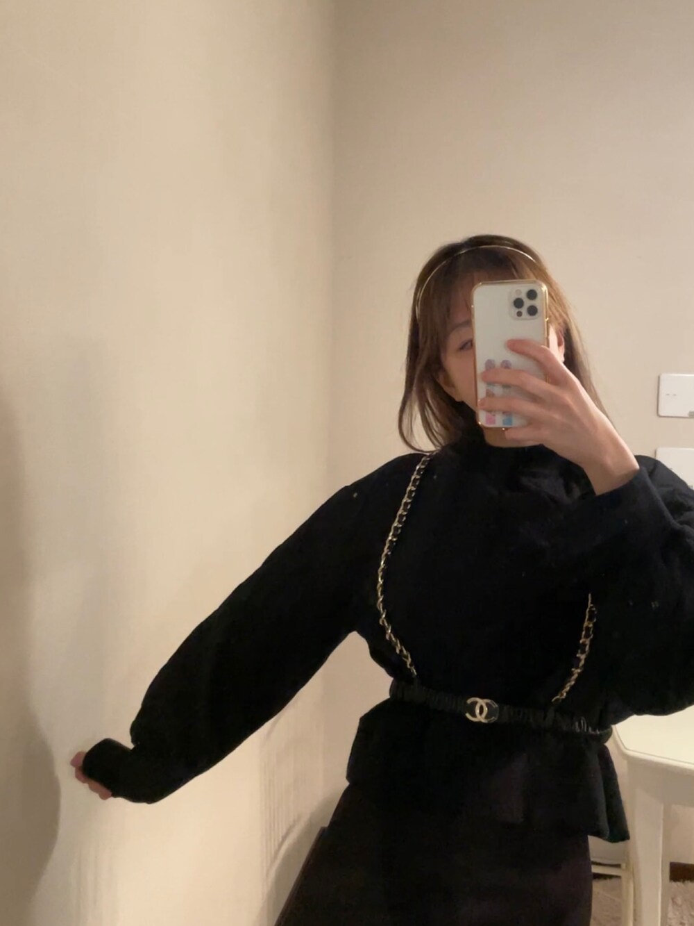 ブラック系のスニーカー、ブラック系のベルト、ゴールド系のカチューシャを着用したレディースの冬コーディネートの2枚目の写真