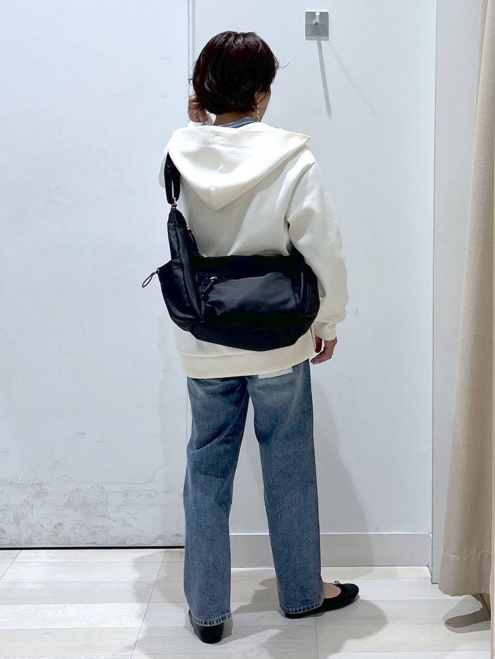ブラック系のショルダーバッグ、ブルー系のデニムパンツ、その他のバレエシューズを着用したレディースの春コーディネートの3枚目の写真