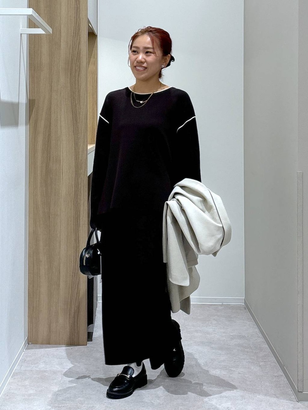 ブラック系のローファー、ブラウン系のワンピース、ブラック系のハンドバッグを着用したレディースの秋コーディネートの5枚目の写真