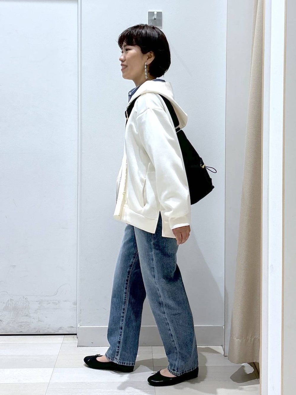 ブラック系のショルダーバッグ、ブルー系のデニムパンツ、その他のバレエシューズを着用したレディースの春コーディネートの2枚目の写真