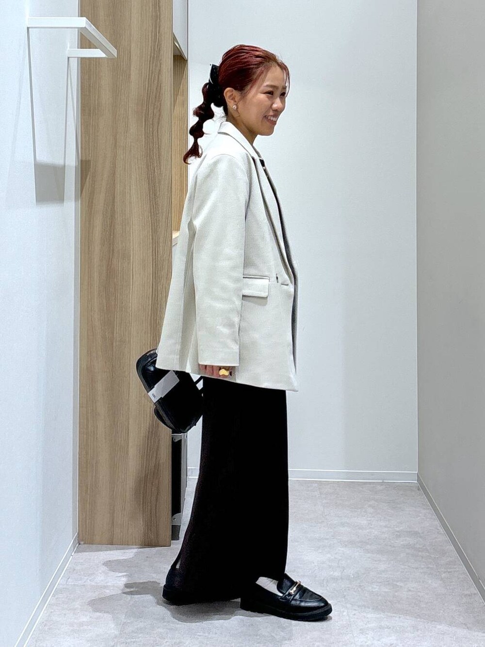 ブラック系のローファー、ブラウン系のワンピース、ブラック系のハンドバッグを着用したレディースの秋コーディネートの3枚目の写真