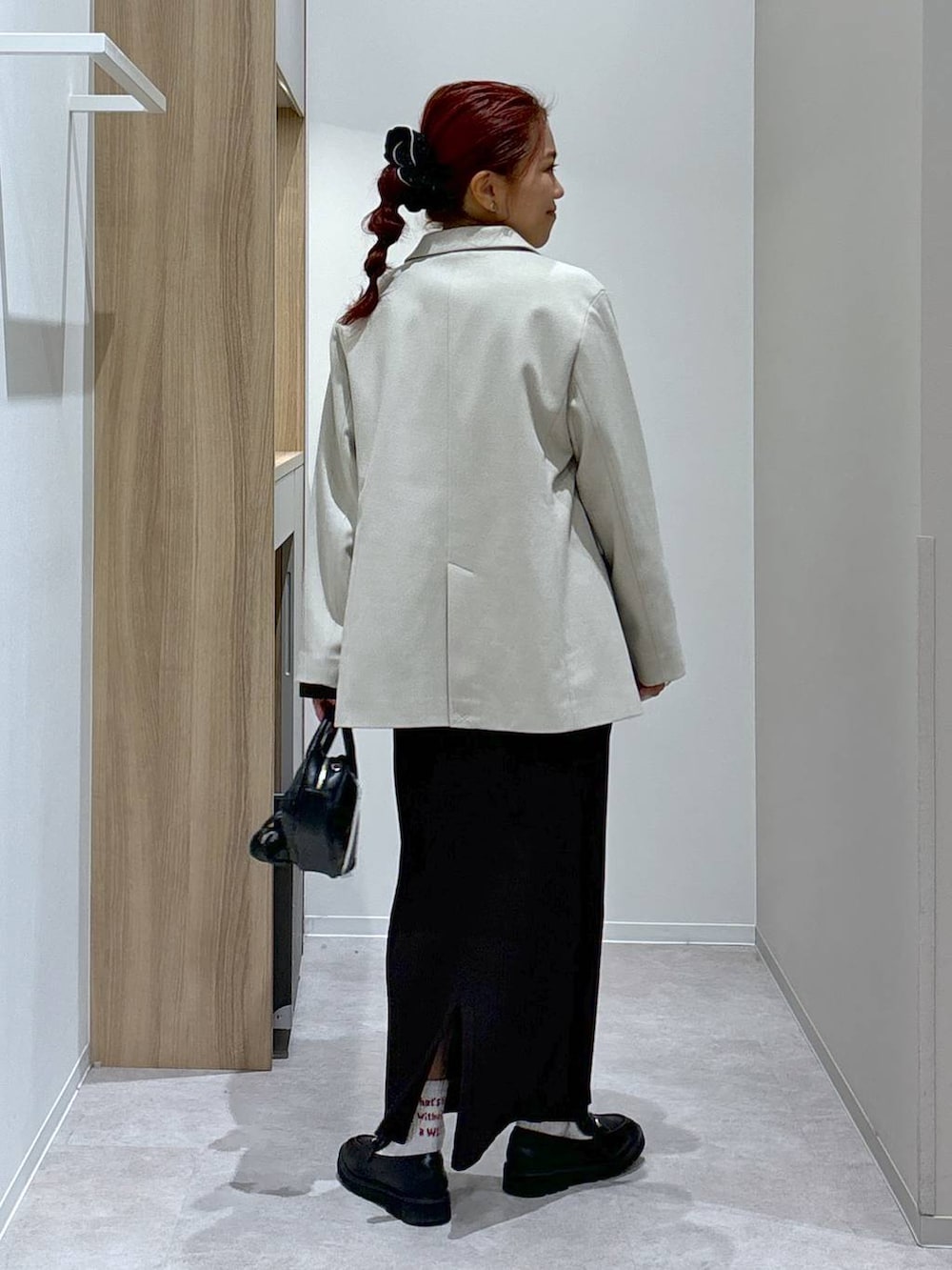 ブラック系のローファー、ブラウン系のワンピース、ブラック系のハンドバッグを着用したレディースの秋コーディネートの4枚目の写真