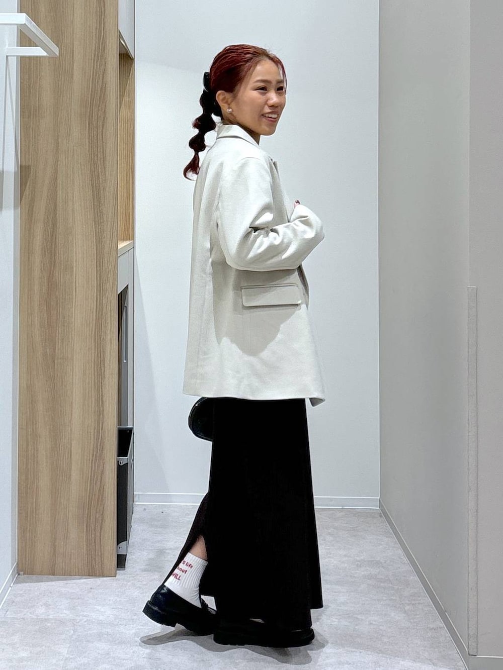 ブラック系のローファー、ブラウン系のワンピース、ブラック系のハンドバッグを着用したレディースの秋コーディネートの2枚目の写真