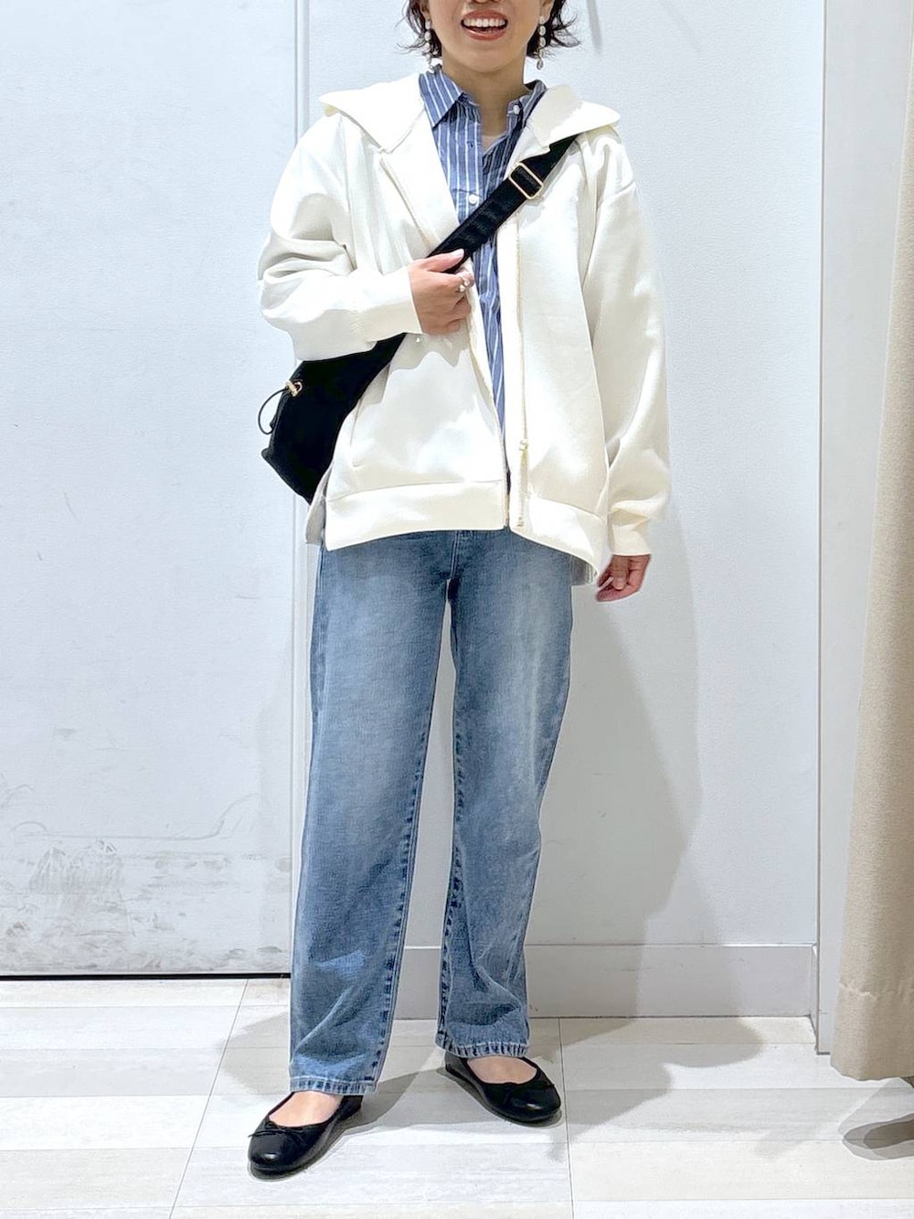 ブラック系のショルダーバッグ、ブルー系のデニムパンツ、その他のバレエシューズを着用したレディースの春コーディネートの5枚目の写真
