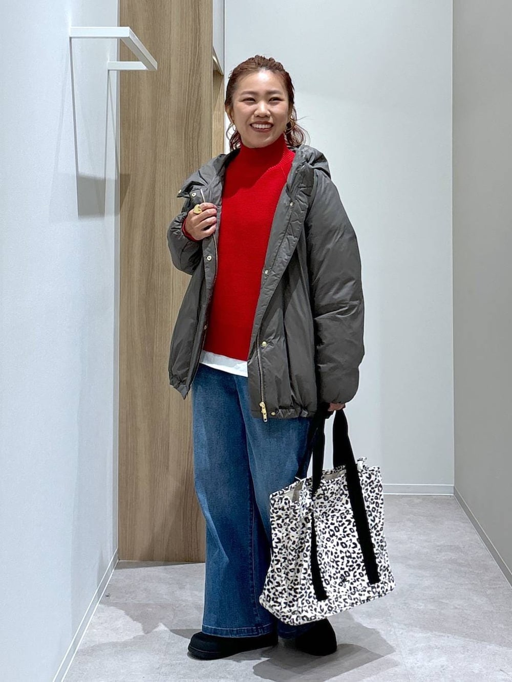 ブラウン系のダウンジャケット/コート、ホワイト系のTシャツ/カットソー、レッド系のニット/セーターを着用したレディースの秋コーディネートの3枚目の写真