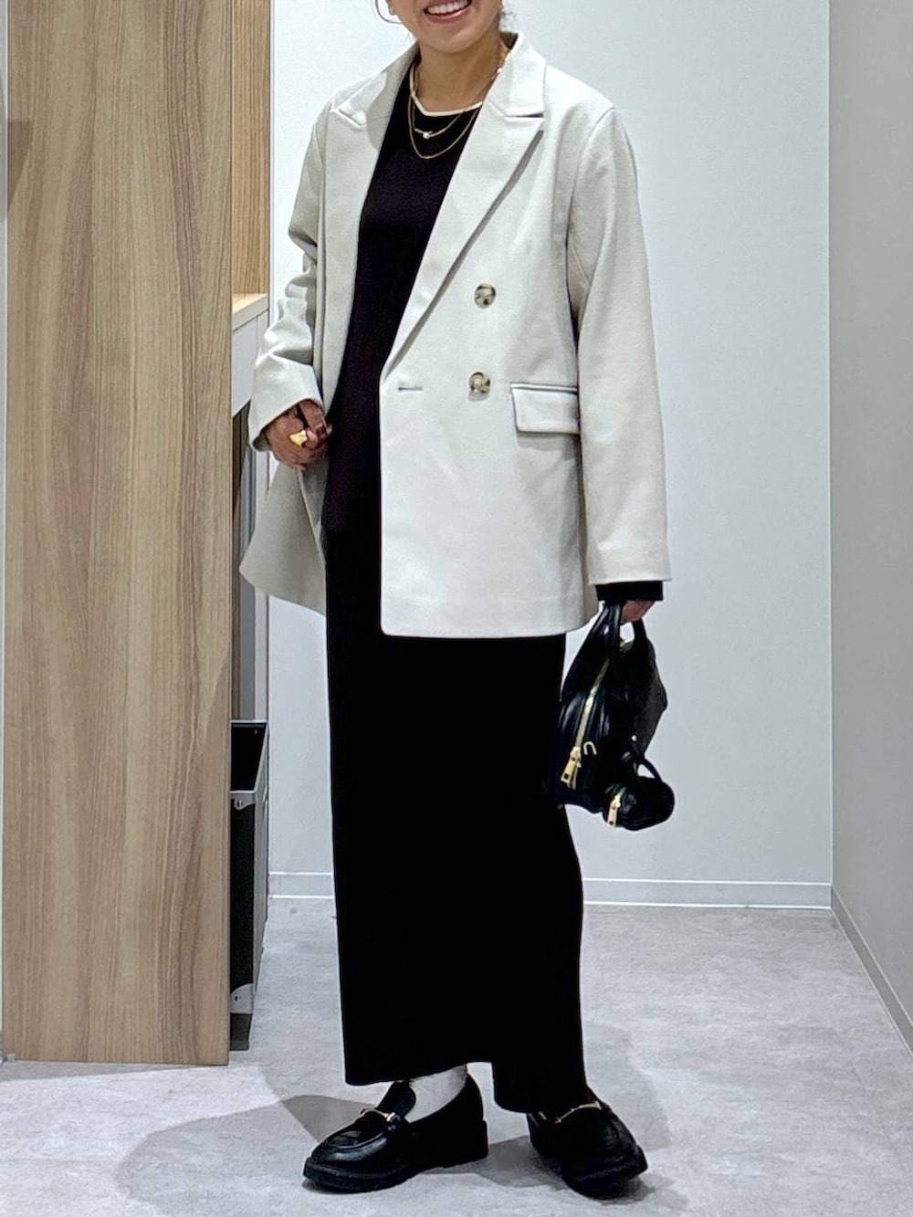 ブラック系のローファー、ブラウン系のワンピース、ブラック系のハンドバッグを着用したレディースの秋コーディネートの8枚目の写真