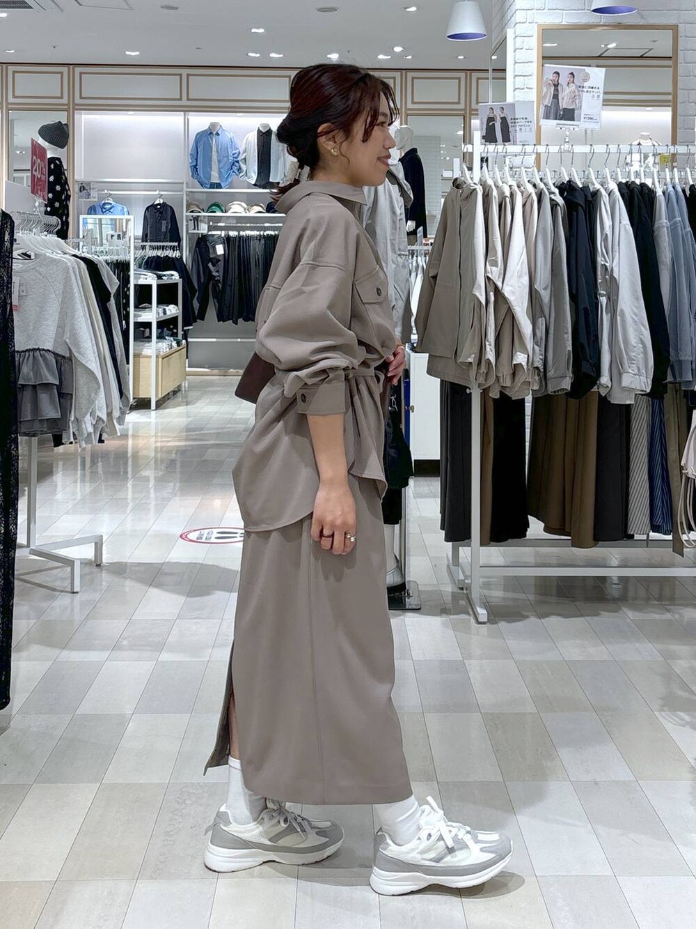 ブラウン系のショルダーバッグ、ブラウン系のスカート、ホワイト系のスニーカーを着用したレディースの春コーディネートの5枚目の写真