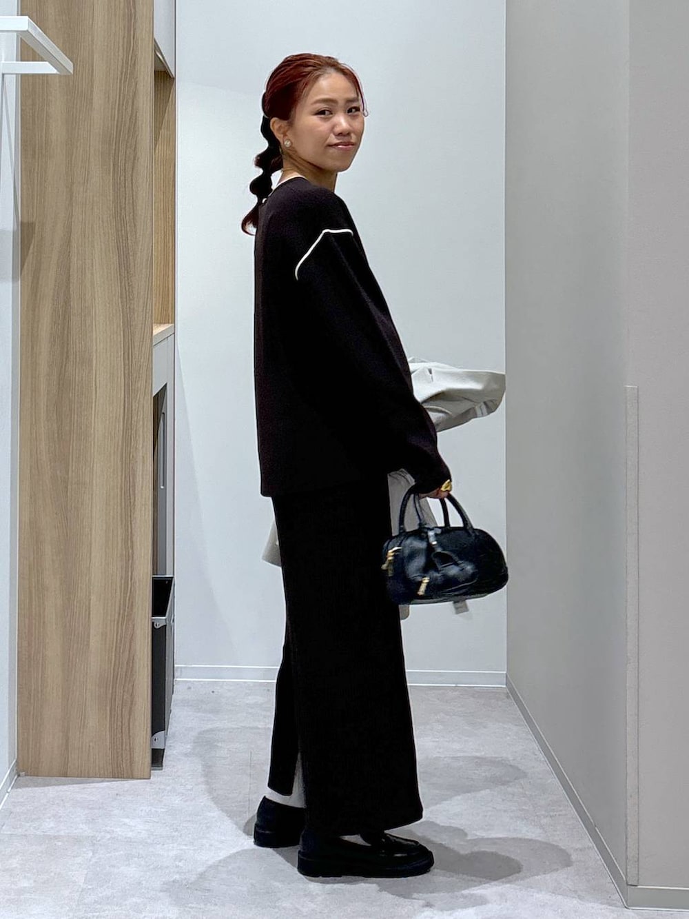 ブラック系のローファー、ブラウン系のワンピース、ブラック系のハンドバッグを着用したレディースの秋コーディネートの7枚目の写真