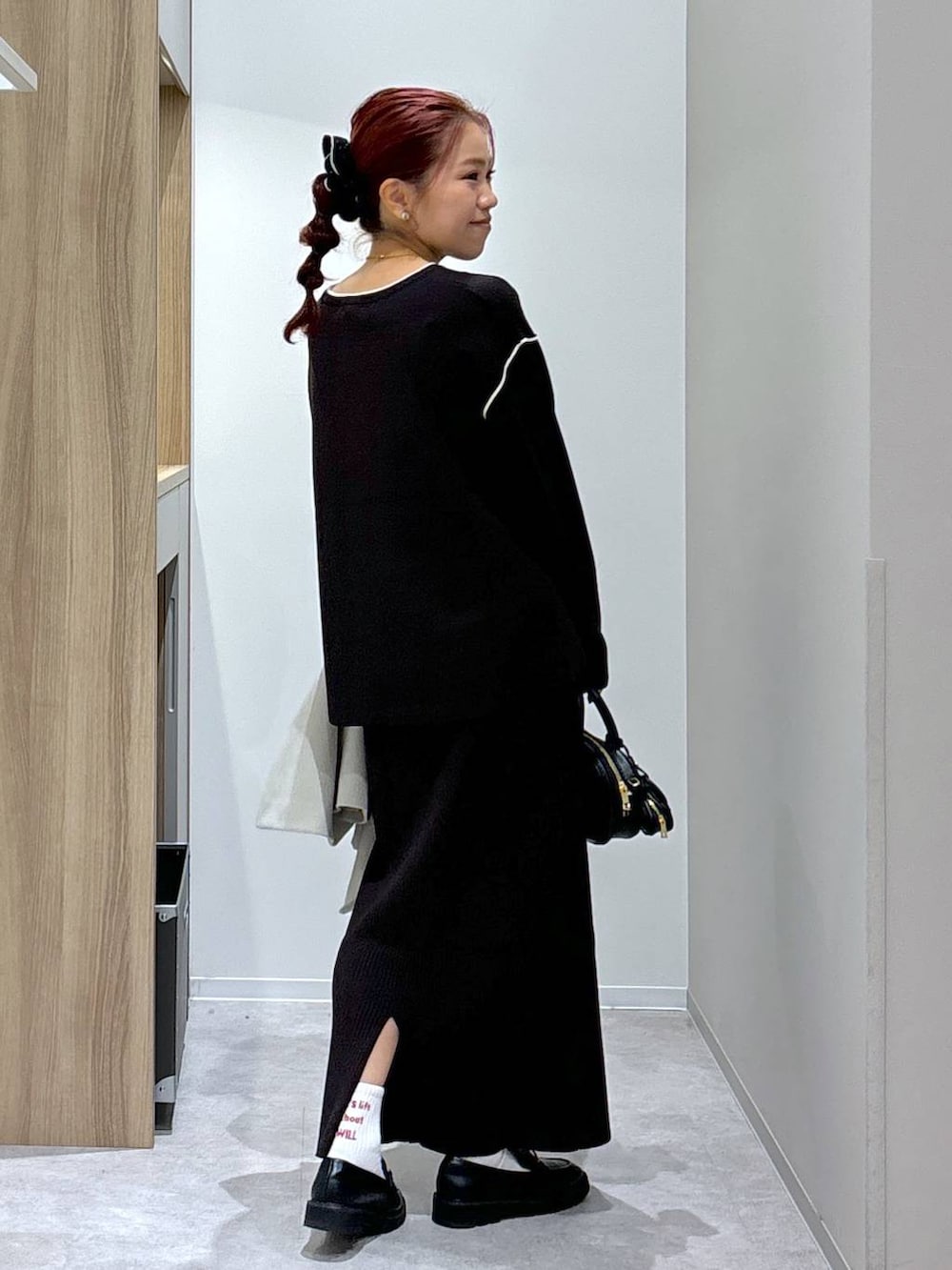 ブラック系のローファー、ブラウン系のワンピース、ブラック系のハンドバッグを着用したレディースの秋コーディネートの6枚目の写真