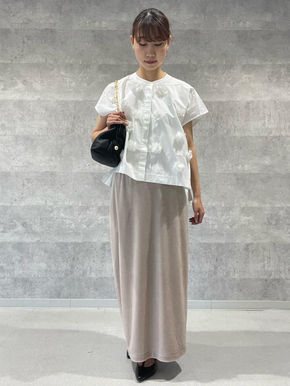 ホワイト系のシャツ/ブラウス、ベージュ系のスカート、ブラック系のショルダーバッグを着用したレディースの夏コーディネートの2枚目の写真